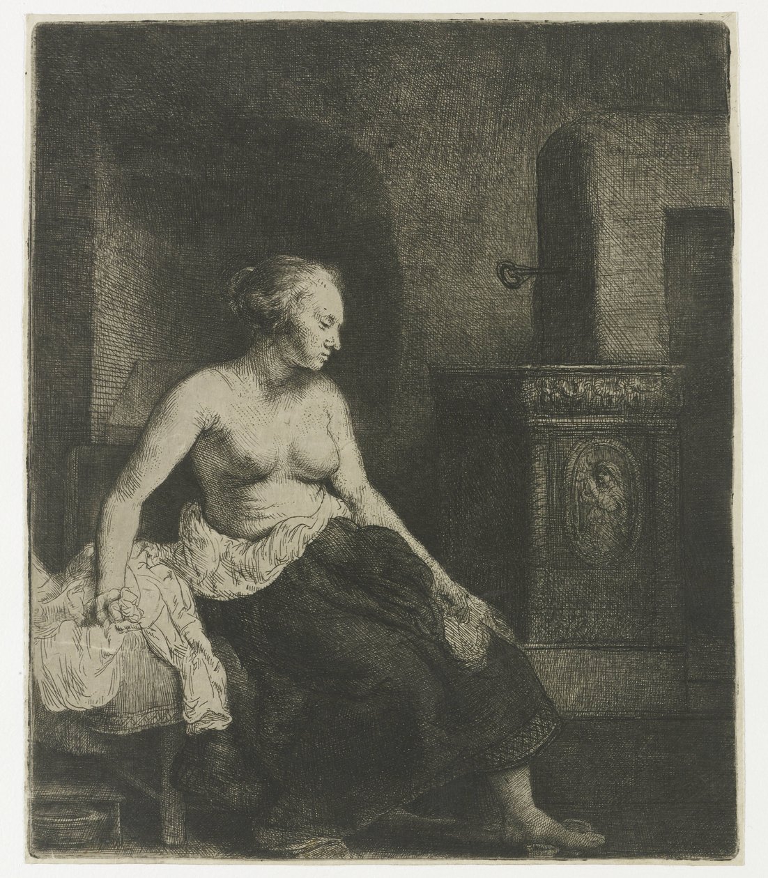 Kvinna som sitter halvklädd bredvid en spis av Rembrandt van Rijn