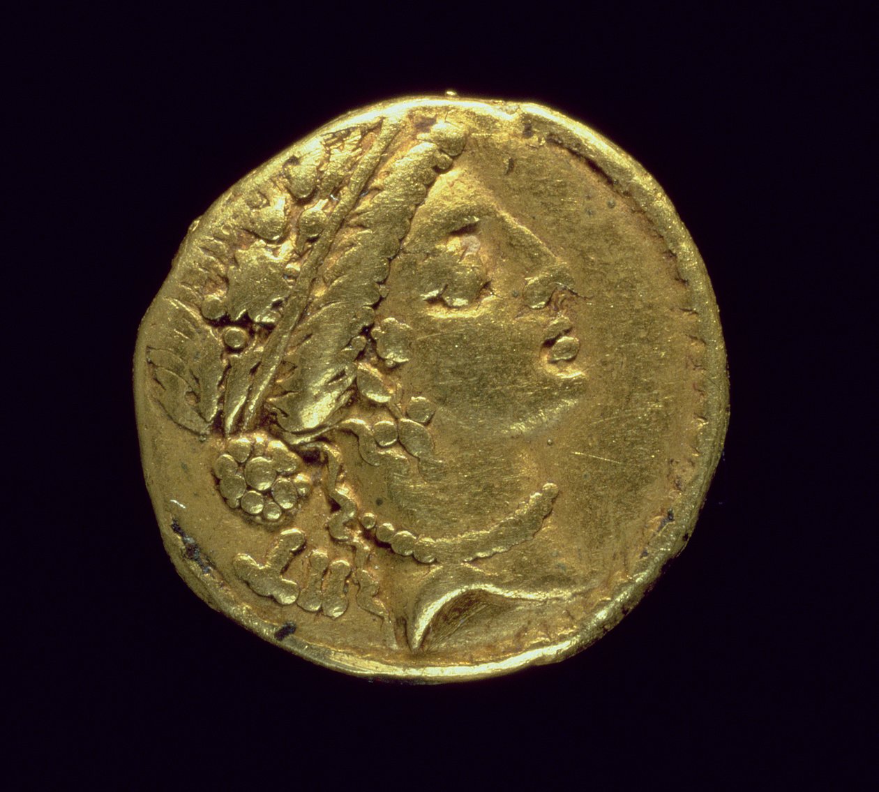 Aureus (framsida) präglad av Julius Caesar (110-44 f.Kr.) föreställande ett kvinnohuvud till höger med en ekkrans och ett diadem (guld). av Roman