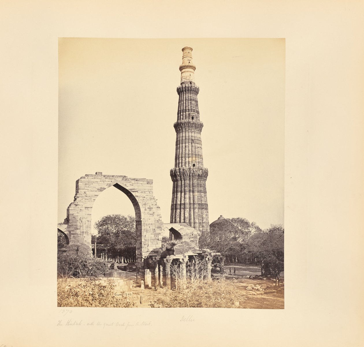 Delhi; Kutub Minar, med den stora bågen, från väster av Samuel Bourne