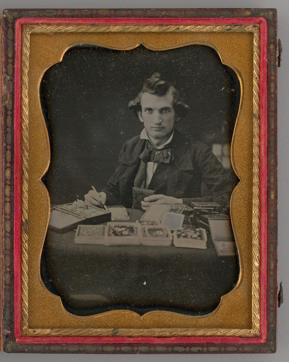 Utan titel porträtt av sittande man som håller en daguerreotypi och borste, 1865. av Samuel J. Miller