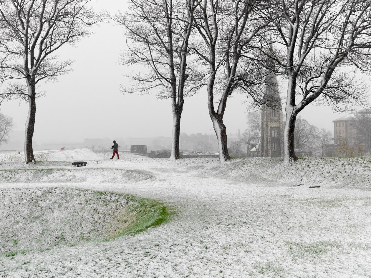 Ensam person på promenad i Köpenhamns fästning under snöstorm, Danmark, 2022 (foto) av Sisse Brimberg