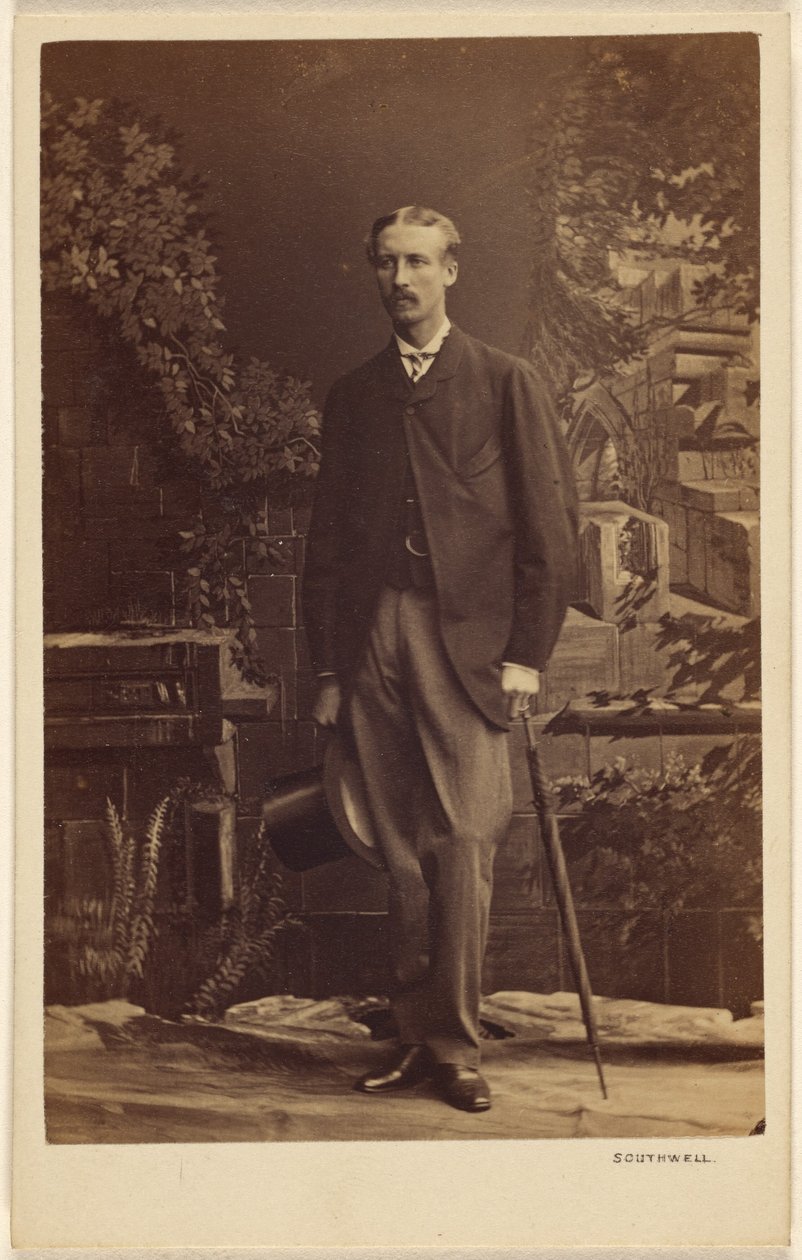 [Oidentifierad man med mustasch, som håller en hög hatt och ett paraply, stående] av Southwell Brothers