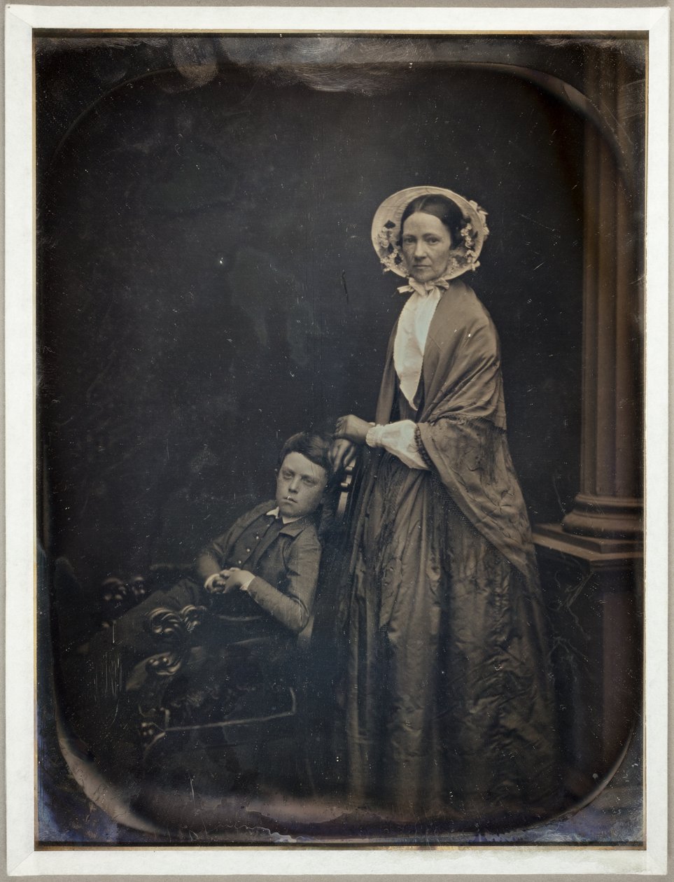 Untitled (En kvinna i motorhuv och sjal, med sin sittande son) av Southworth and Hawes