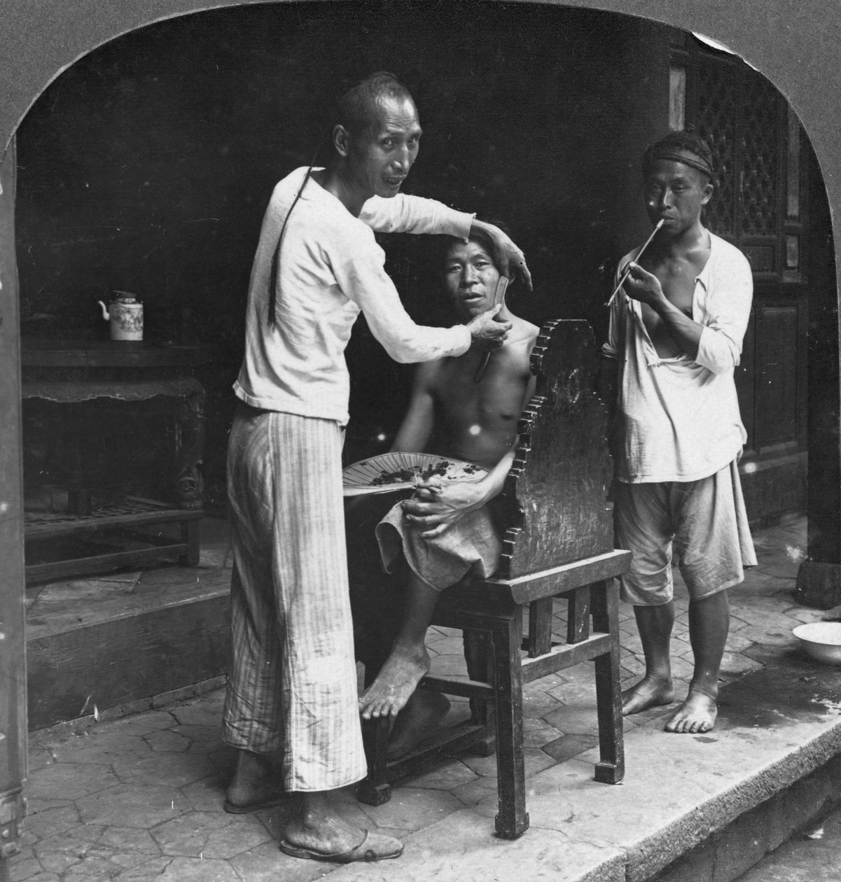 En kinesisk frisör i Bhamo, Burma, 1908 av Stereo Travel Co