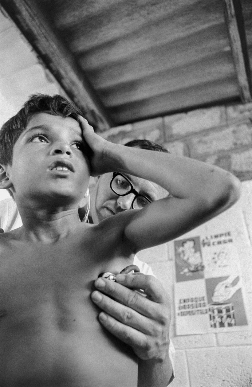 Amerikansk läkare använder stetoskop för att diagnostisera ett sjukt barn från Equador på sjukhusfartyget SS Hope av Ted Spiegel