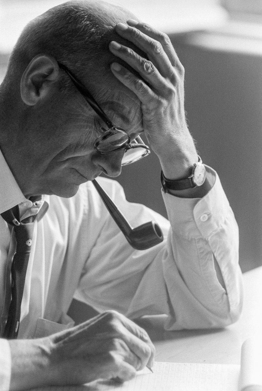 Dr. Benjamín Viel, chilensk läkare studerar ett dokument och röker pipa. av Ted Spiegel