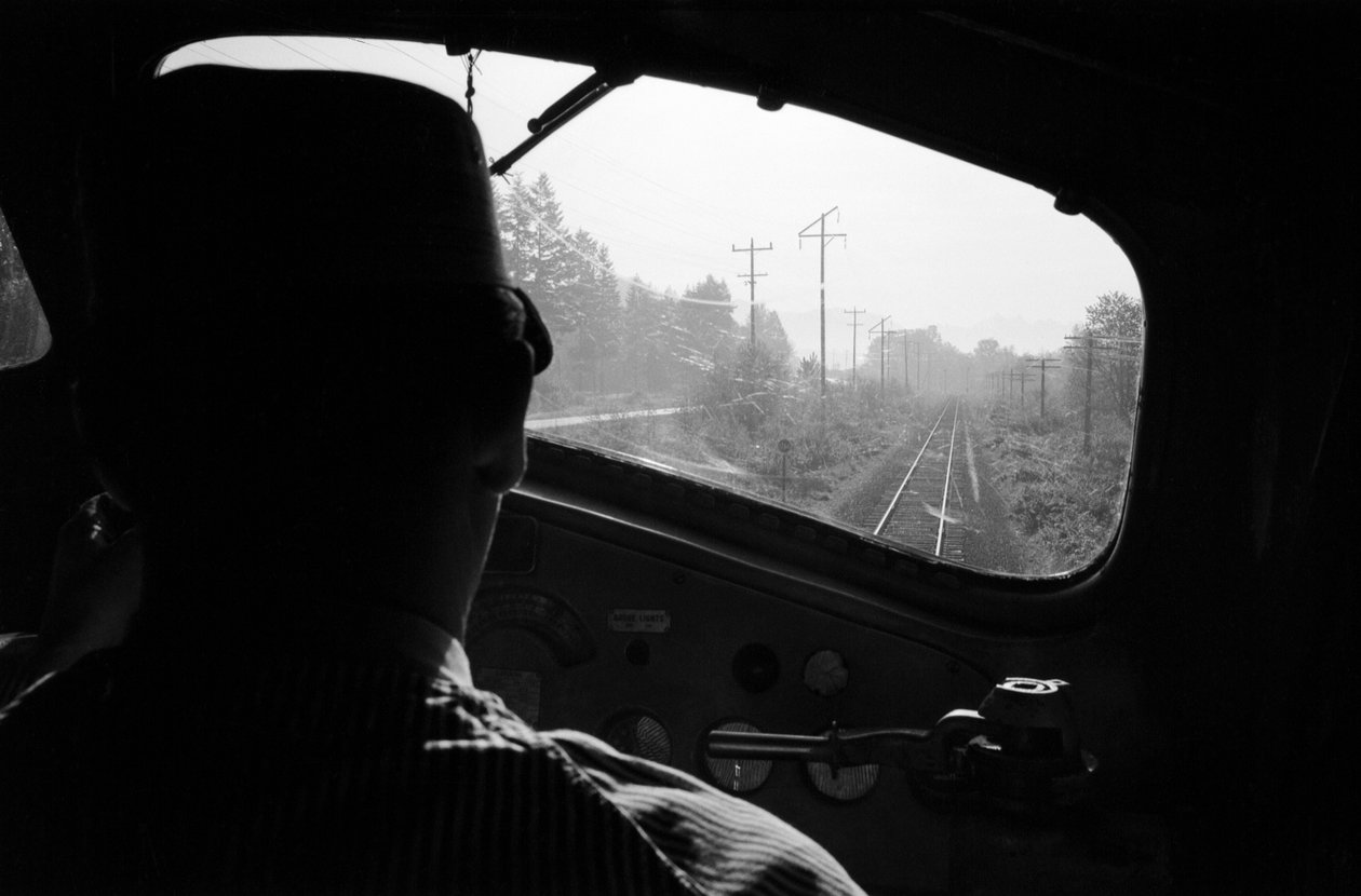 Vy över spåren från förarhytten på ett diesellok med lokföraren, Pacific Northwest av Ted Spiegel
