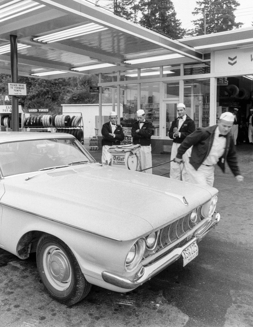 Unga män som utbildar sig till bensinstationsbiträden på Chevron-station av Ted Spiegel