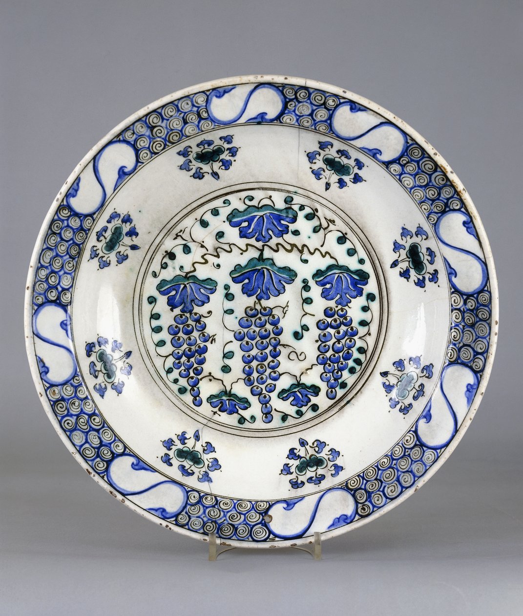 En Iznik keramikfat, med en central runddel som visar tre klasar av druvor och vinblad, ca 1570 (keramik) av Turkish School