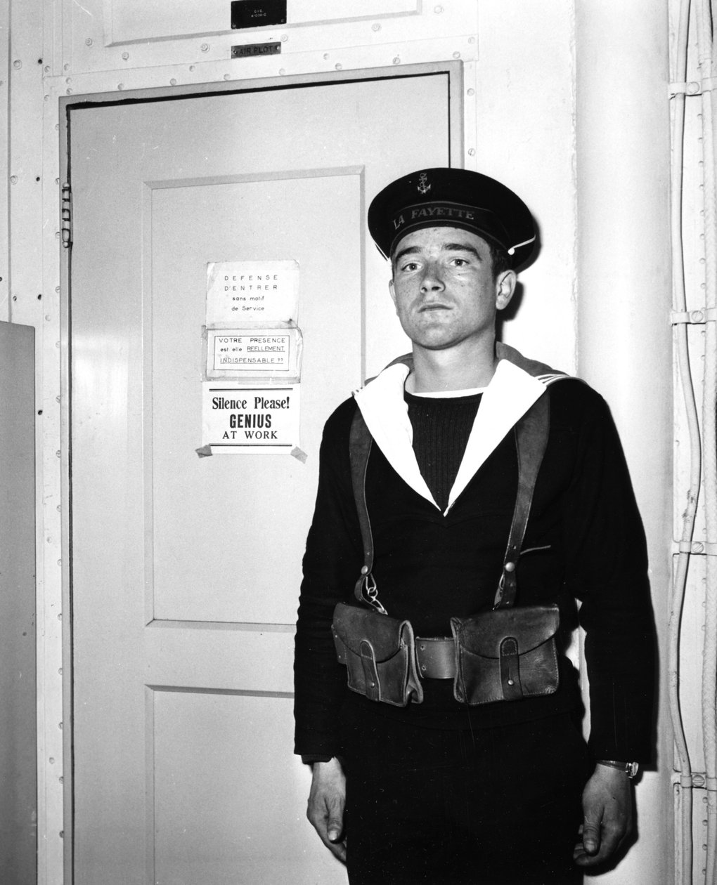 En fransk vaktpost utanför operationsrummet på hangarfartyget La Fayette, 1951 av Unbekannt
