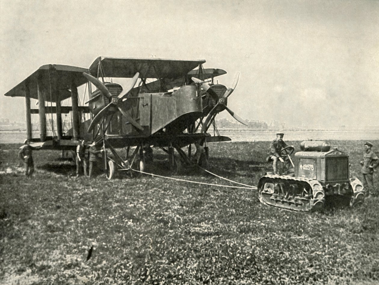 En liten motortraktor som får en enorm R.A.F. Bombmaskin i position..., 1919. av Unbekannt