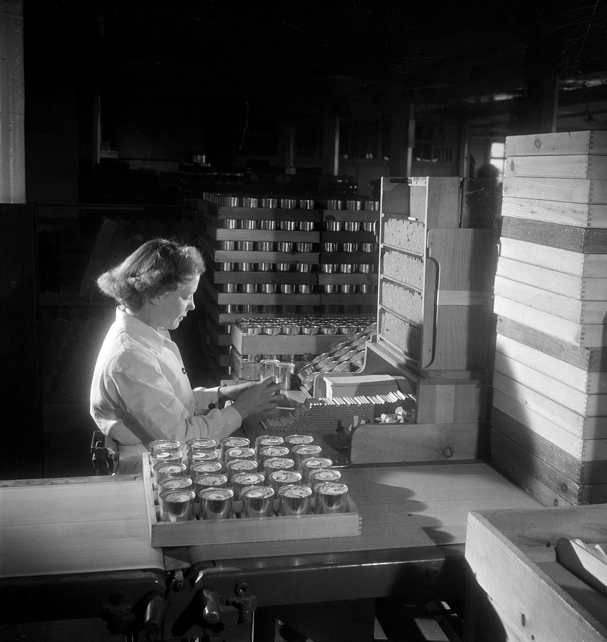 En kvinnlig arbetare packar burkar cigaretter, London 1950 av Unbekannt