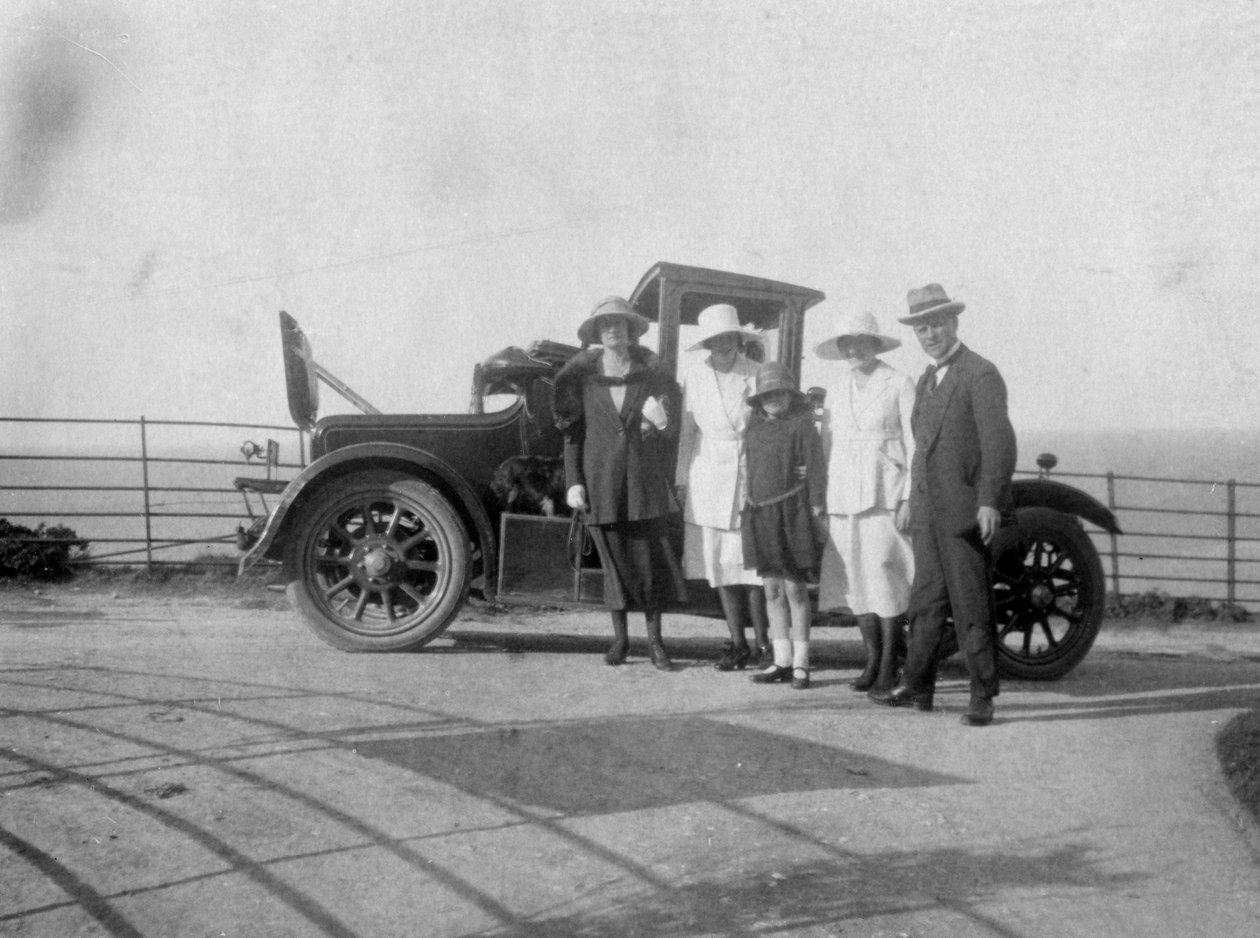 En grupp människor framför sin bil vid havet, c1920-talet av Unbekannt