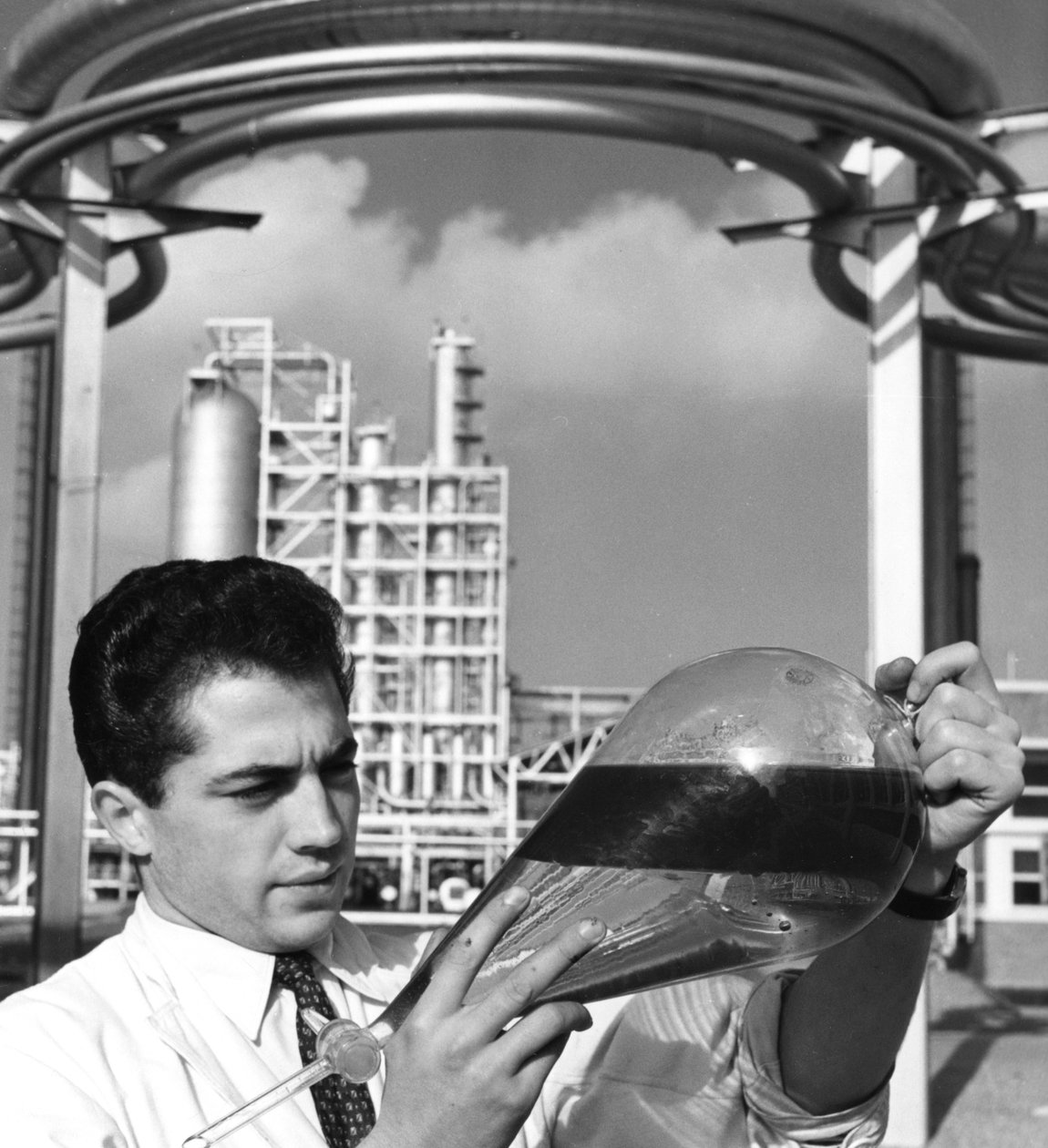 En laboratoriearbetare håller i en separertratt med olja, raffinaderiet i Dunkirk, Frankrike, 1950-talet av Unbekannt