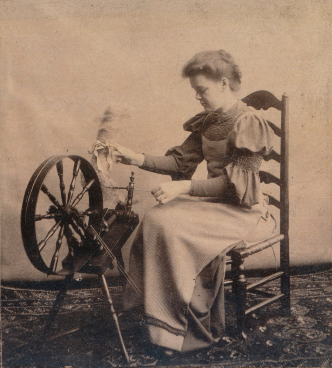 En dam vid ett snurrande hjul c1900 av Unbekannt