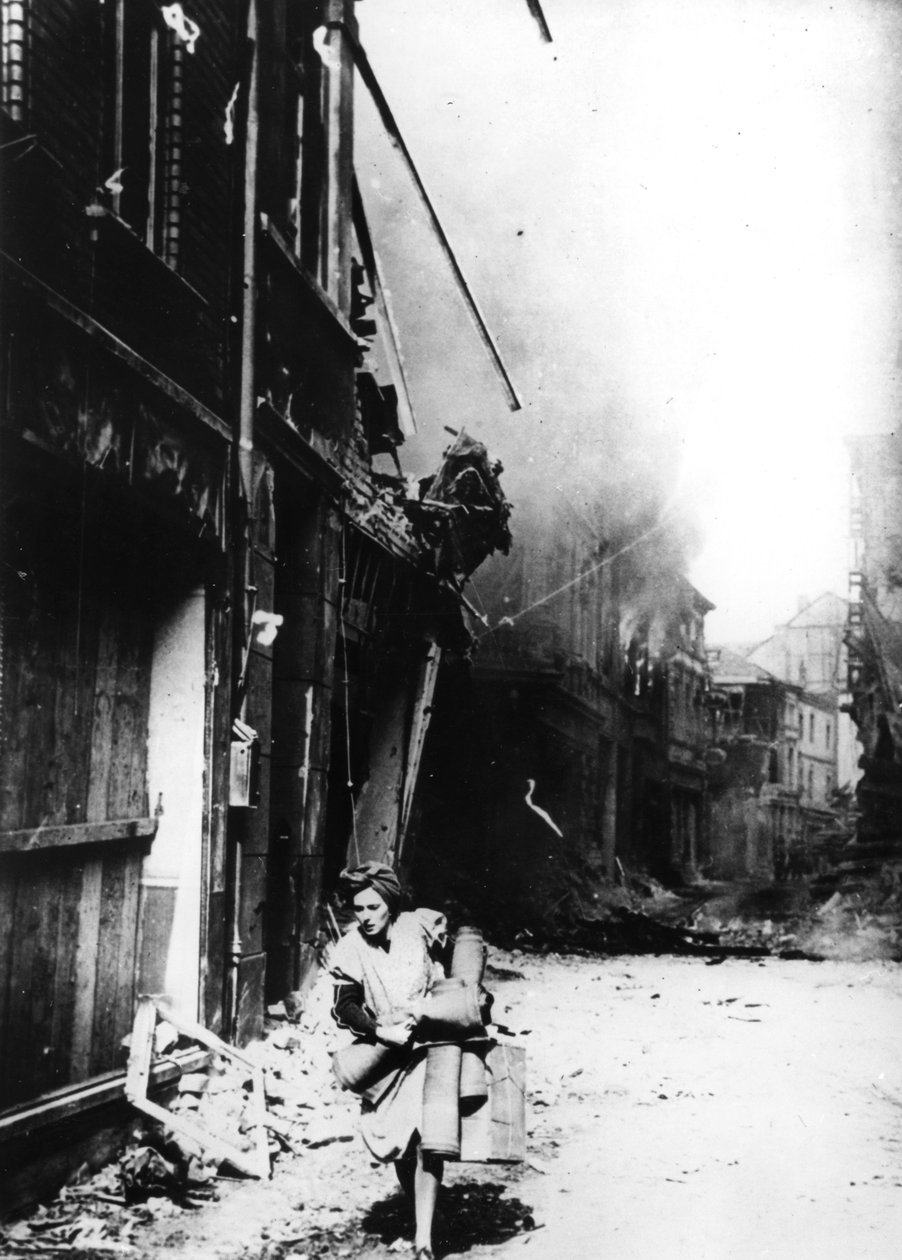 En kvinna som lämnar sitt brinnande hus på en bombad gata, Tyskland, 1945 av Unbekannt