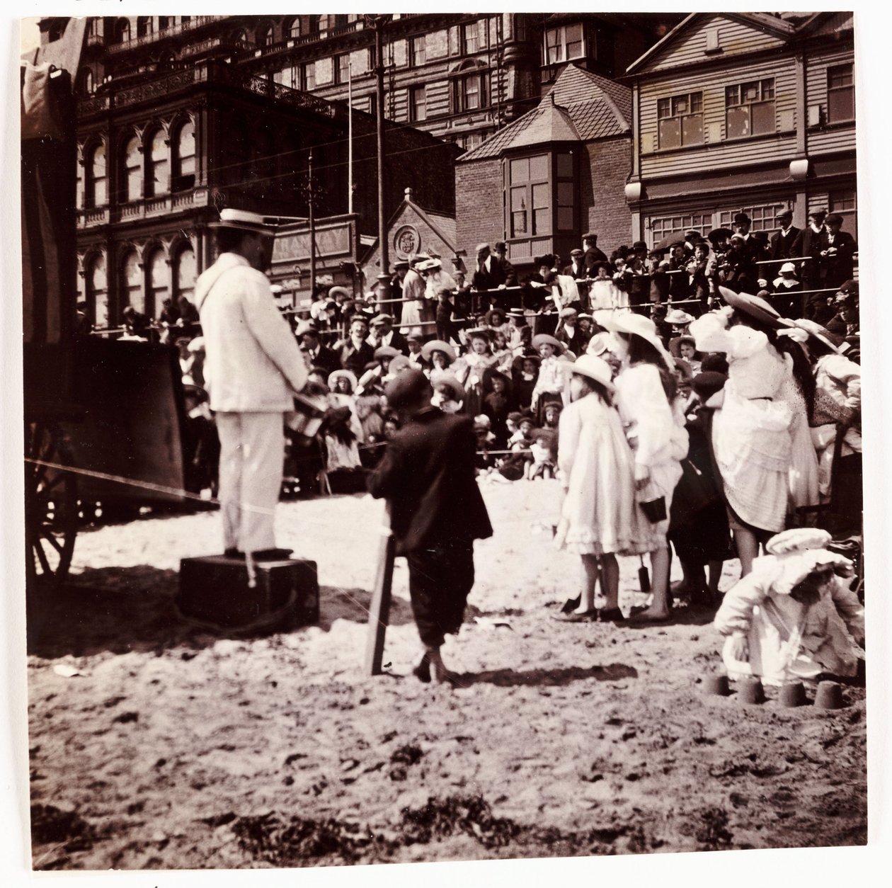 Folkmassa tittar på en strandunderhållare, c 1905 av Unbekannt