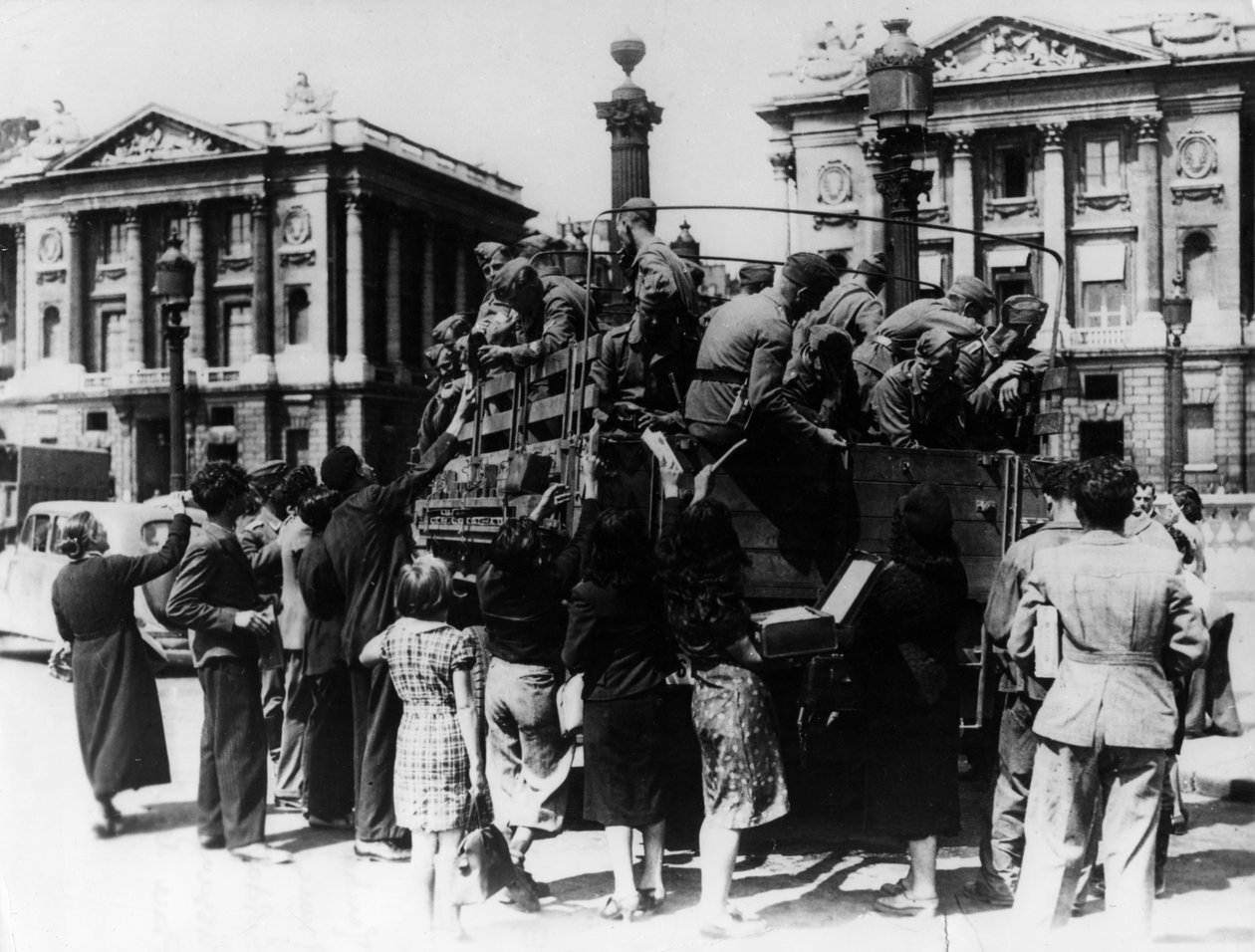 Franska gatuförsäljare som erbjuder souvenirer till en lastbil med tyska soldater, Paris, 27 juli 1940 av Unbekannt