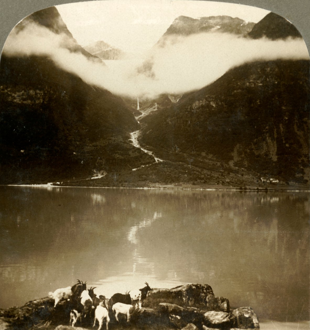 Grytereidsglaciären glittrar ovanför drivande moln, över den lugna sjön Olden, Norge, c1905. av Unbekannt