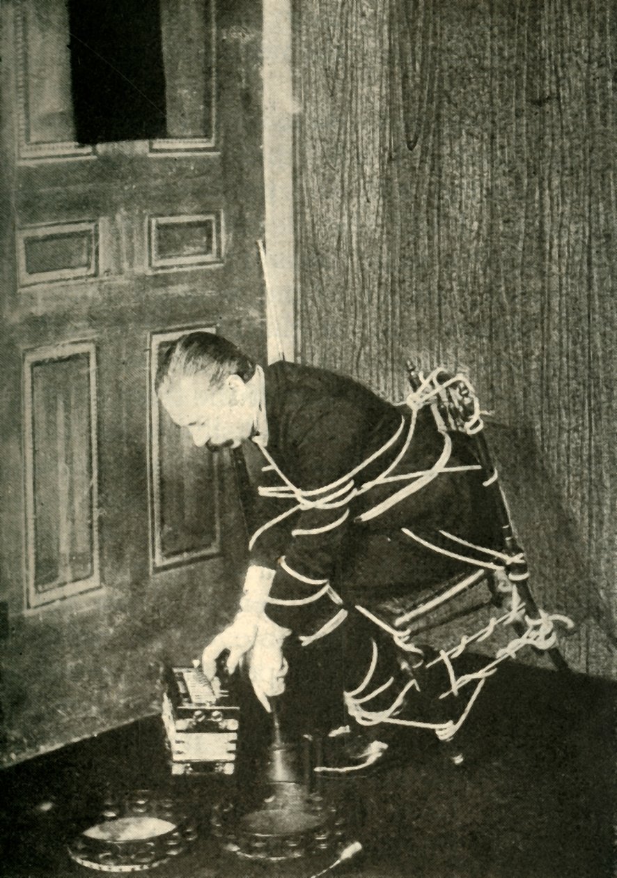 John Nevil Maskelyne utför en andekabinettillusion, c1910. av Unbekannt