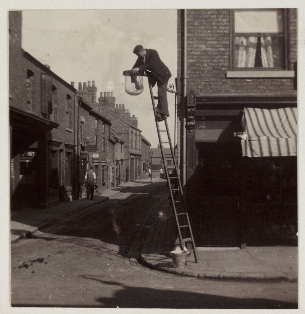 Man som rengör en gasgatlykta, c 1905 av Unbekannt