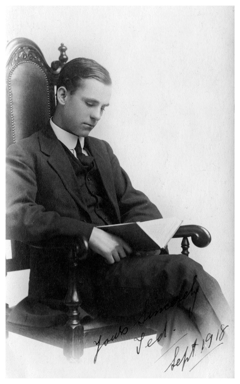 Man sitter i en stol och läser en bok, 1918 av Unbekannt