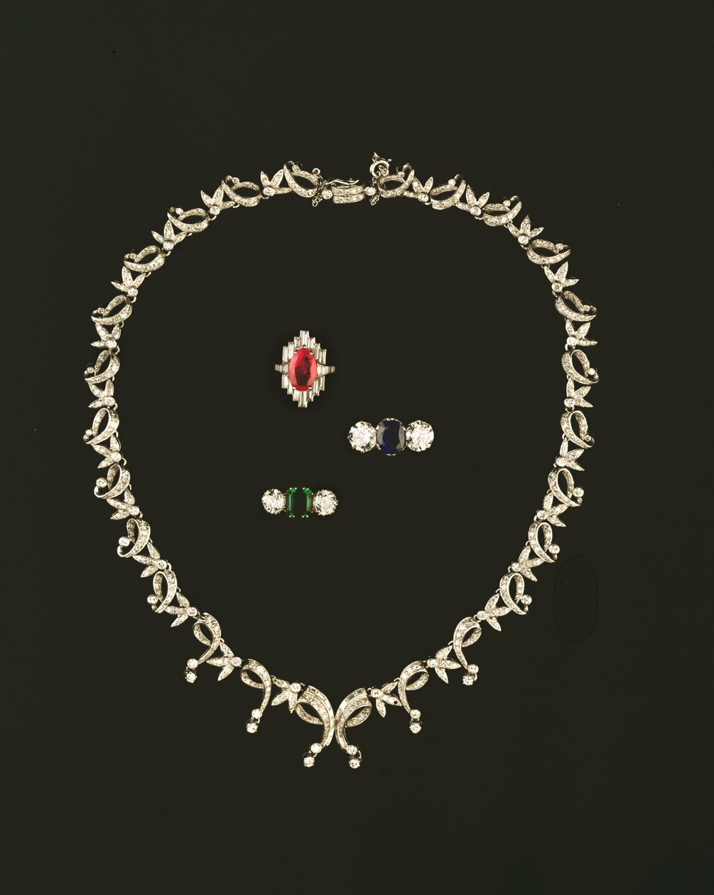 Art Deco rull- och bladdesignhalsband; rubin och diamant baguette kluster ring; trestensring av safir och diamant; smaragd och diamant trestensring av Unbekannt Unbekannt
