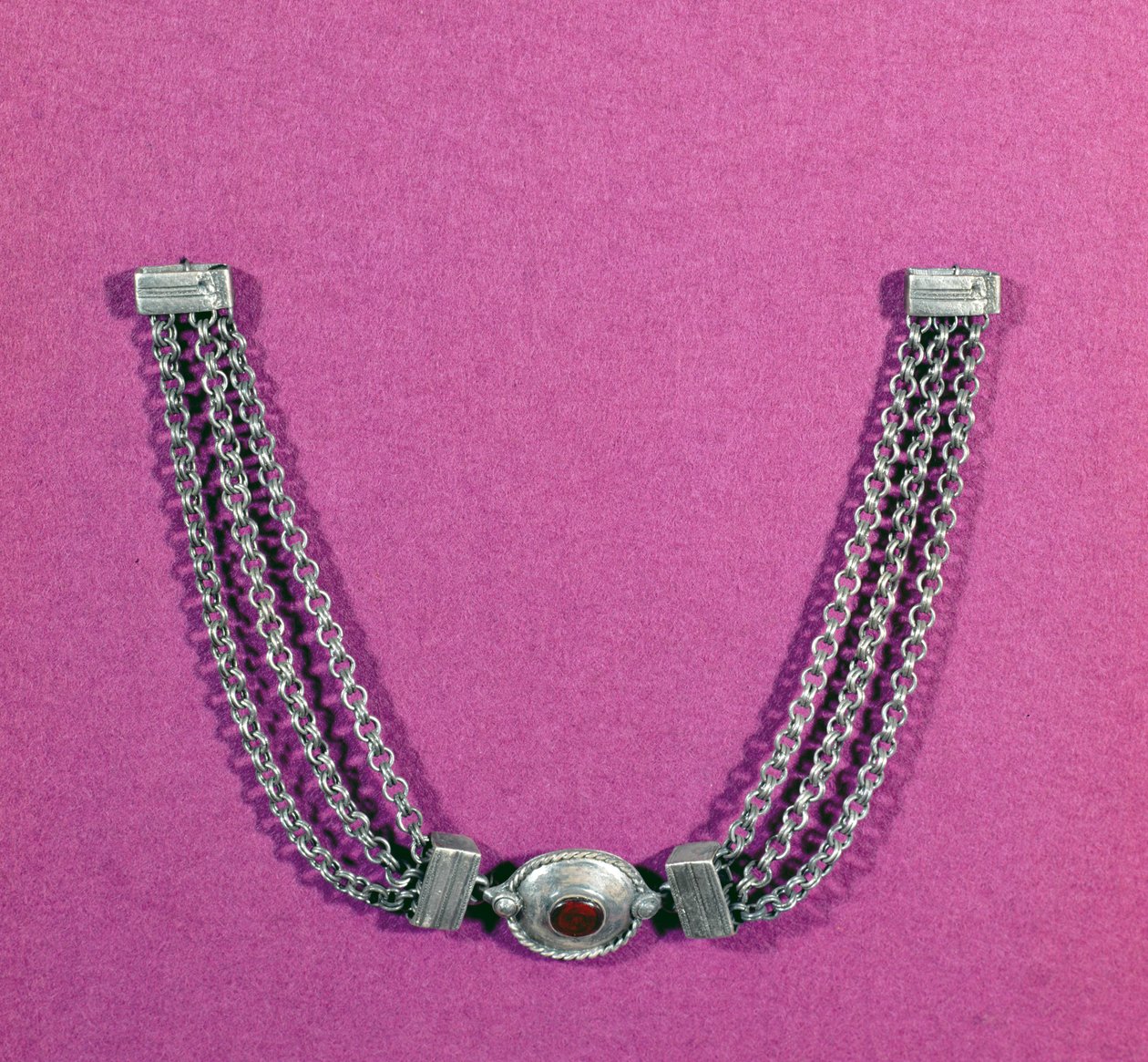 Silverhalsband bestående av en cornelian, i en oval miljö kantad med en kabellist, upphängd mellan två längder av tre kedjor fästa med ett lådliknande spänne, hittat i Great Chesters, mitten 1:a till av Unbekannt Unbekannt