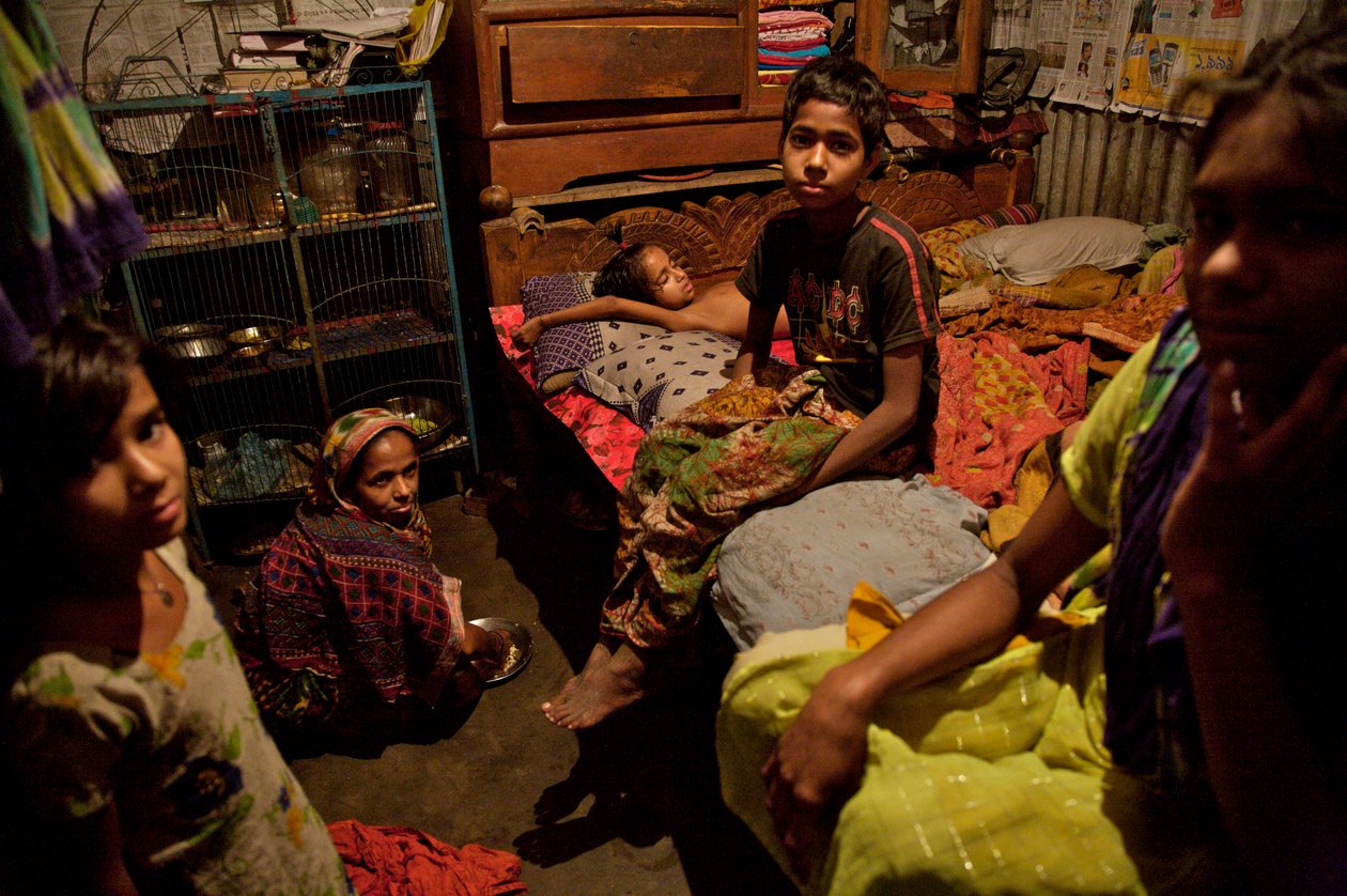 En familj, i bambuslummen, nära Buriganga-floden, i Gamla Dhaka, Bangladesh. 21 februari 2007. Så många som 6 till 10 personer bor i 10 fot gånger 10 fots rum och delar gemensam handpump, toalett och kök mellan sig. De flesta som bor i sådana ho av Unbekannt Unbekannt