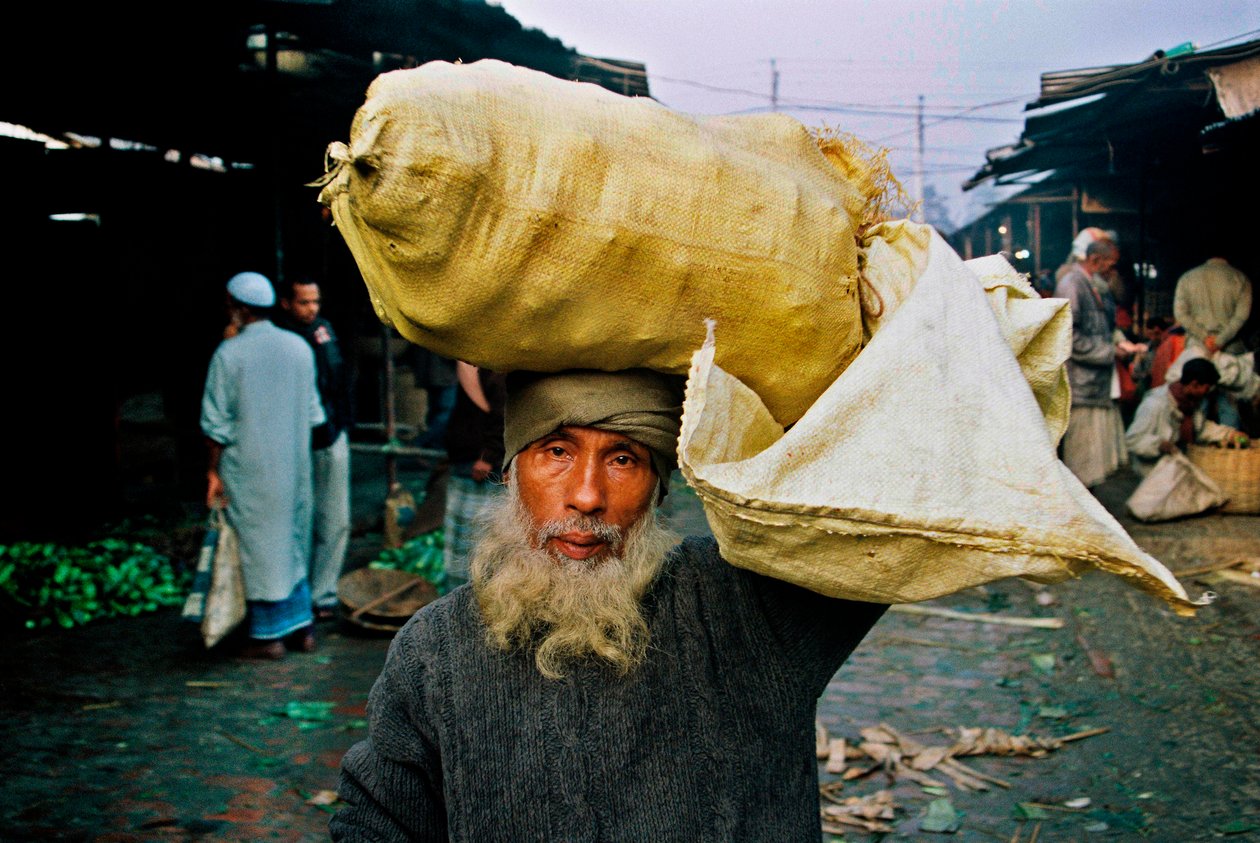 Porträtt av en grönsakssäljare. Abdus Samad köper grönsaker på hålmarknaden och säljer dem på gatan. Nirala kacha bazar, Khulna, Bangladesh. av Unbekannt Unbekannt