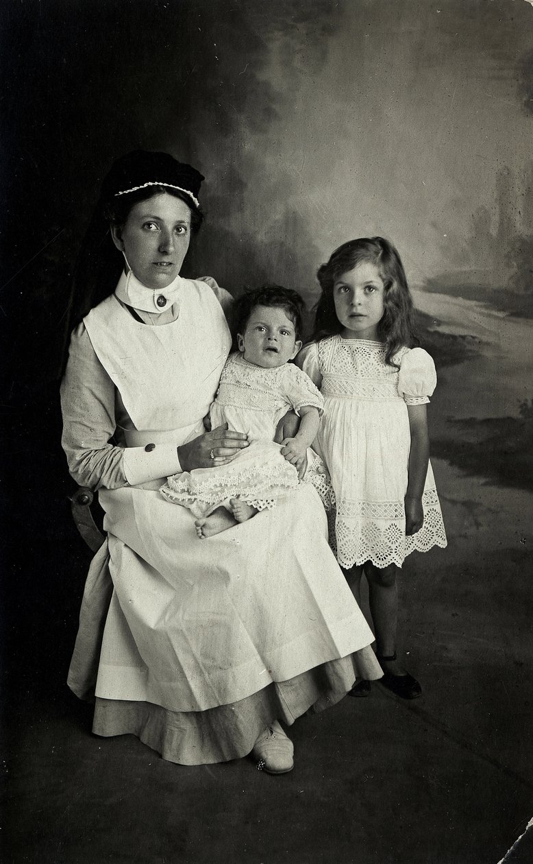 En "sköterska" poserar med barn på 1920-talet. av William M. Timlin