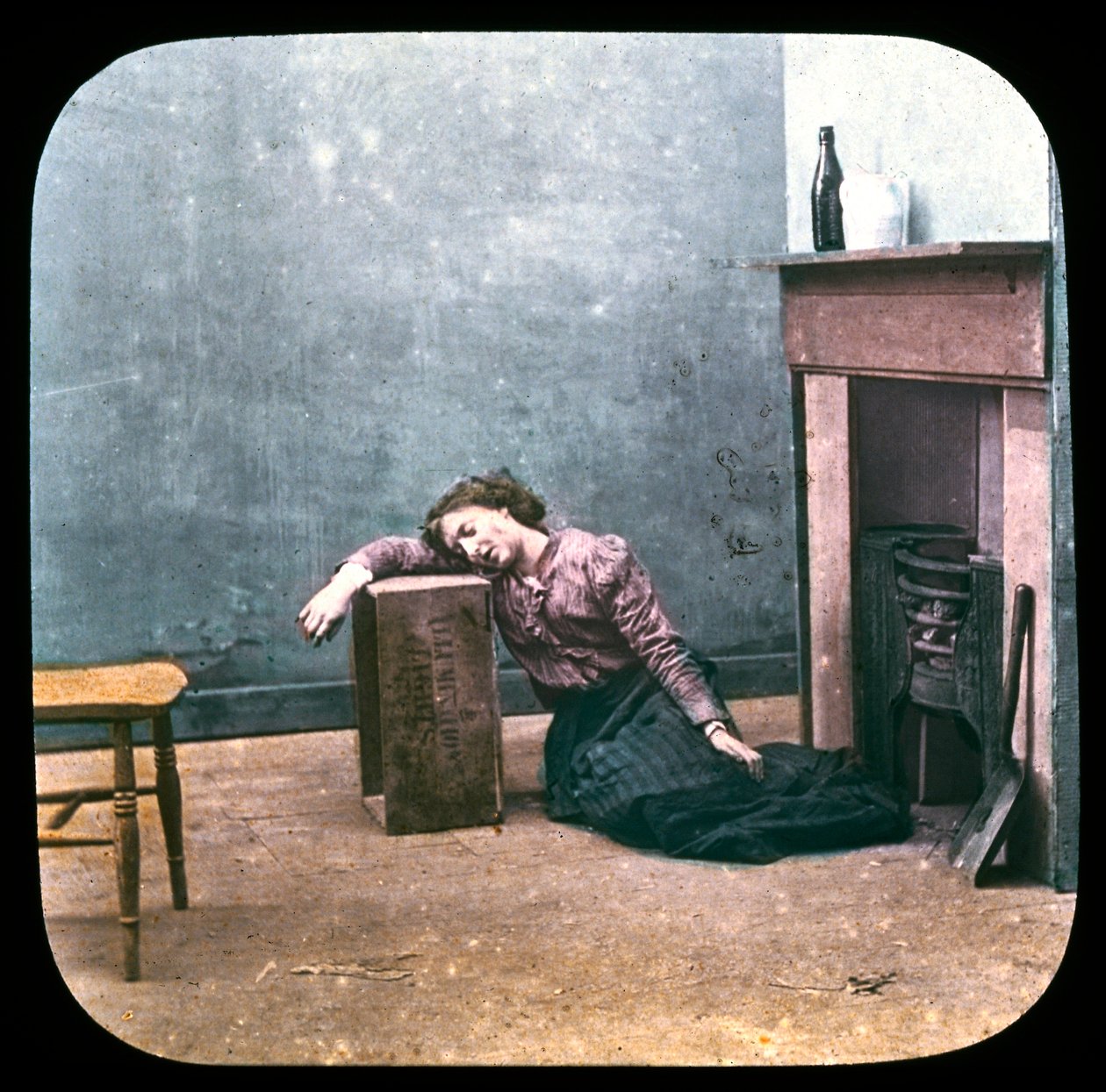 Berusad kvinna på golvet framför den öppna spisen, ca 1895 av Unbekannt