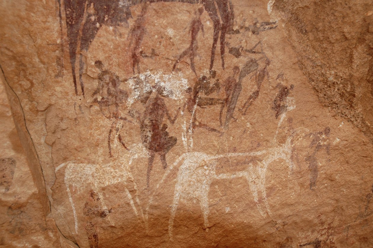 Hällkonst, förhistoria: Stenmålning av karaktärer och kor i ett utsmyckat skydd i Uweinat-massivet, Sudan (Karkur-Talh eller Karkur Talh). Period från 8000 till 3000 år f.Kr. Fotografi av Unbekannt