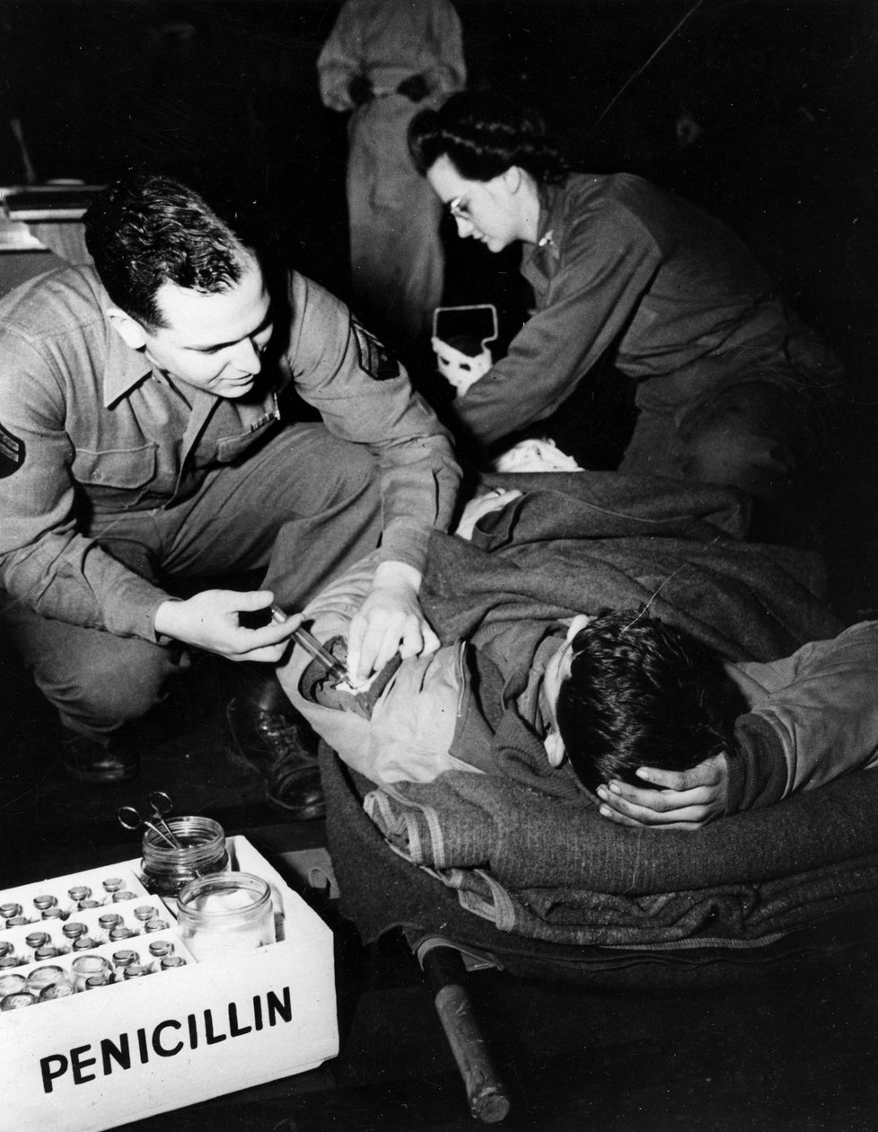 Andra världskriget (1939-1945) - Andra världskriget (WWII eller WW2): Luxemburg februari 1945: På ett evakueringssjukhus i den amerikanska armén administrerar en läkare (sjuksköterska) penicillin till en skadad soldat för att undvika infektion medan en sju av Unbekannt
