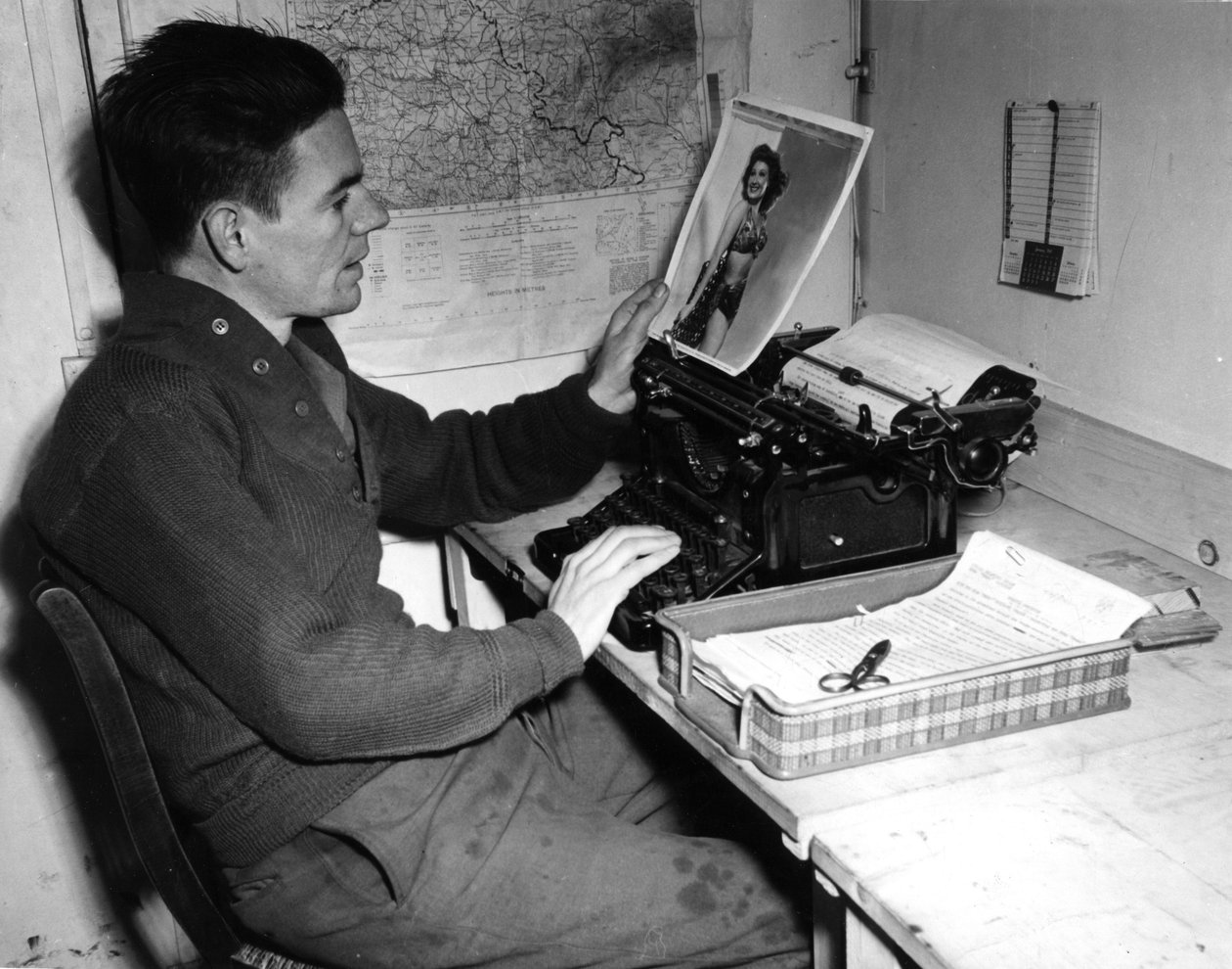 Andra världskriget (1939-1945) - Andra världskriget (WWII eller WW2): Mutzig (Alsace) Frankrike 1 december 1944: Korpral Flanertys krönikör vid Beachead News (GI:s nyhetstidning) tittar på ett pin-up fotografi som han publicerar i nästa nummer av tidningen av Unbekannt