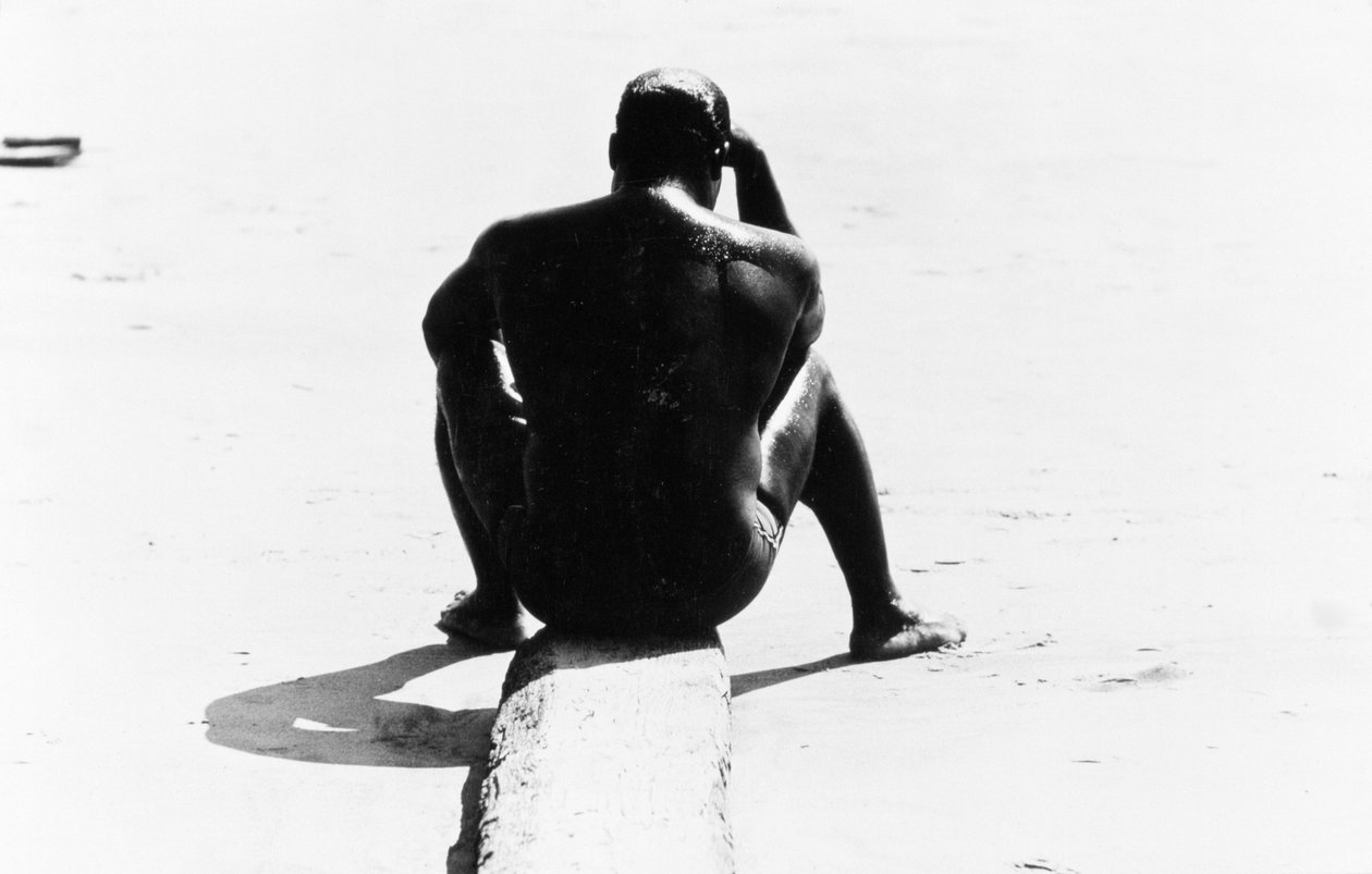 Sittande man utan överkropp på Coney Island, Untitled 32, c.1953-64 (s/v foto) av Unbekannter Künstler