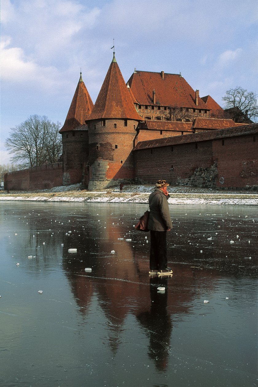 Sideprofil af en mand, der står på en frossen flod foran et slot, Nogat River, Malbork Castle, Malbork, Pomorskie Province, Polandswed av Benjamin Baud
