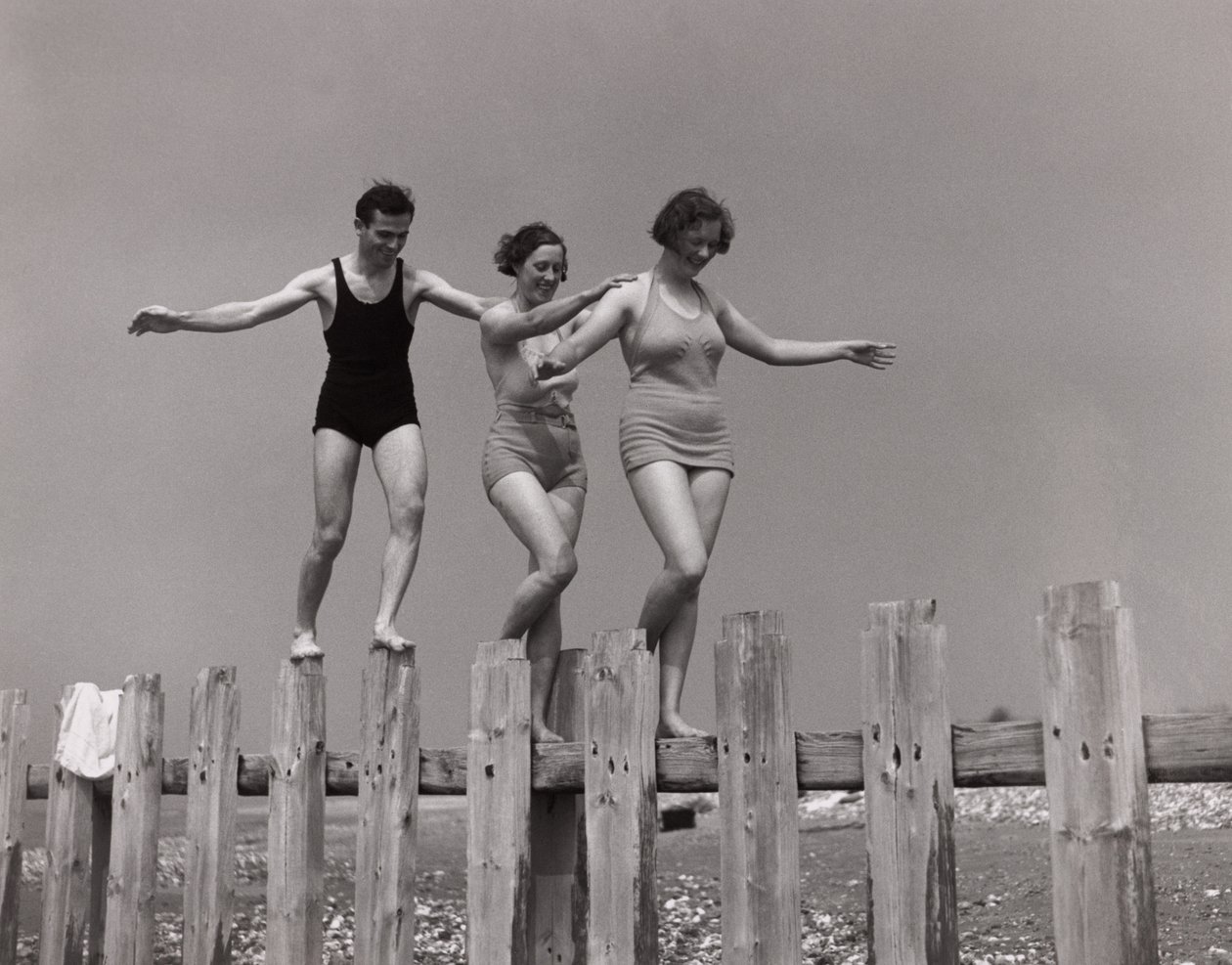 Två kvinnor och en man som går längs en groyne, ca 1930-talet av Unbekannt
