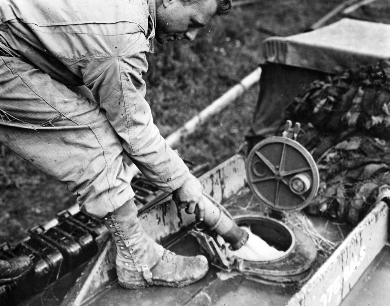 Andra världskriget (WWII) (1939-1945) - Andra världskriget (WWII eller WW2): Normandie (Frankrike) Sommaren 1944: På en bensinstation tankar en soldat från ett amerikanskt transportföretag bränsle till tanken på en GMC-tanker av Unbekannt