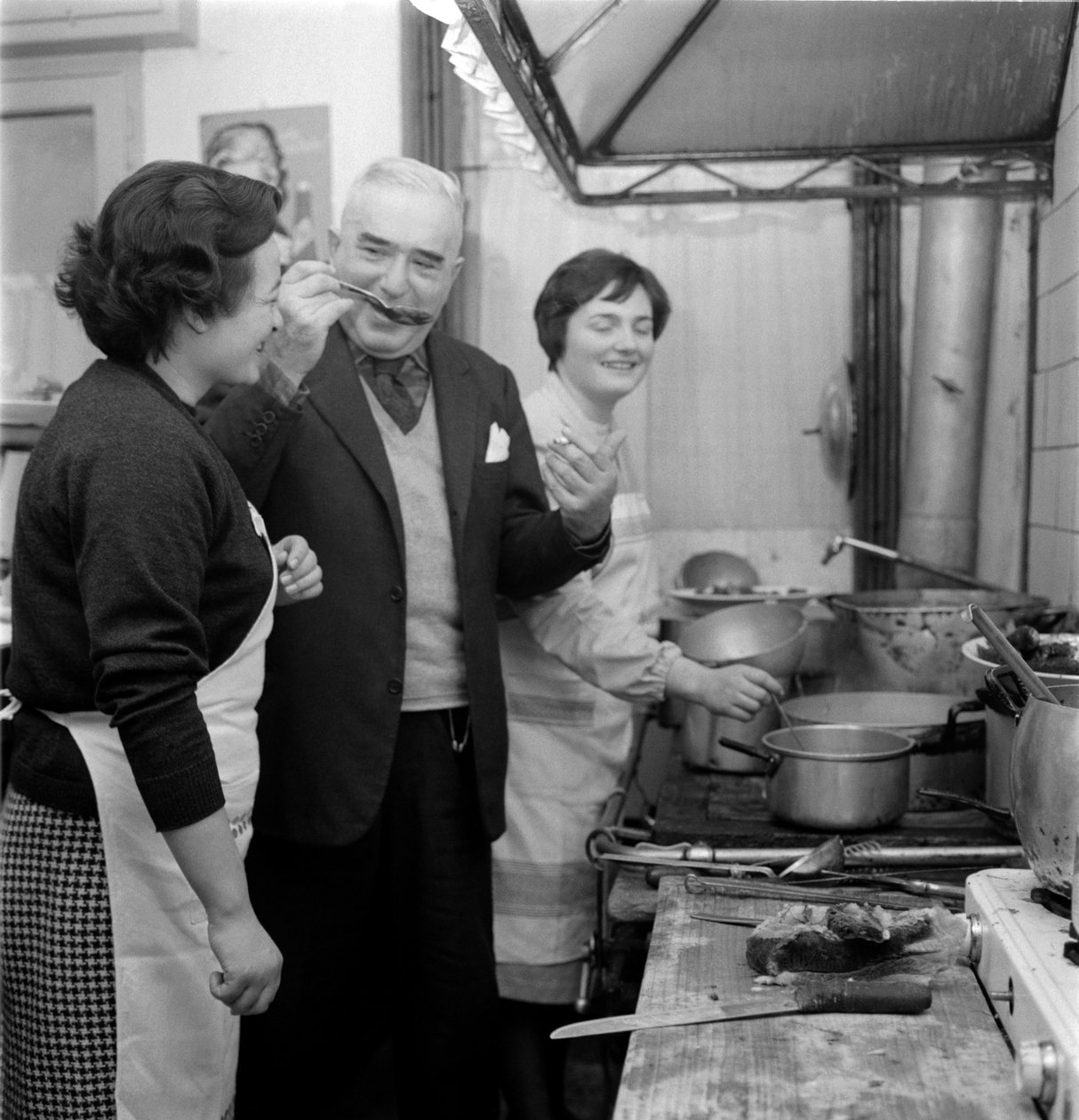 Författaren GIOVANNI COMISSO i sitt hus i TREVISO (han smakar en maträtt i köket) - 1962 av Unbekannt