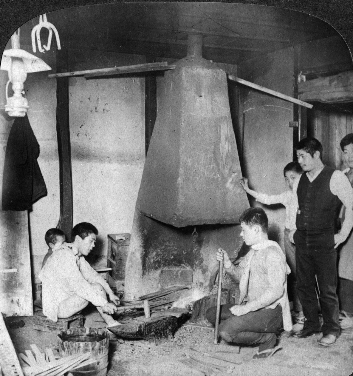 En japansk smed vid sin smedja, Yokohama, Japan, 1904. av Underwood and Underwood