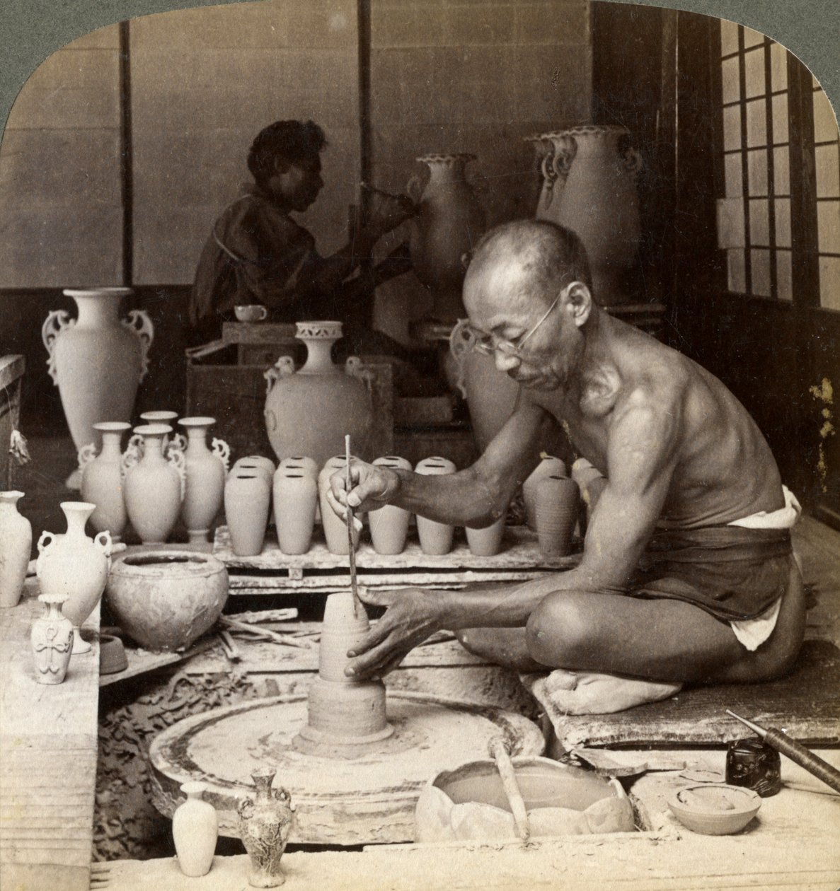 En krukmakare och hans hjul, skapar en vas av Awata-porslin, Kinkosan-verk, Kyoto, Japan, 1904 av Underwood and Underwood