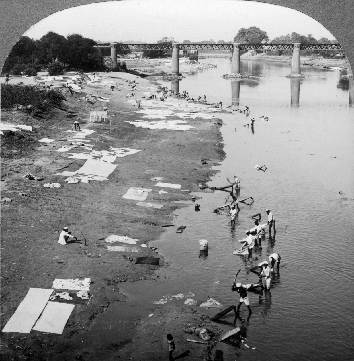 Dobbies tvättar kläder i Gomti River, nära Lucknow, Indien, 1900-talet. av Underwood and Underwood