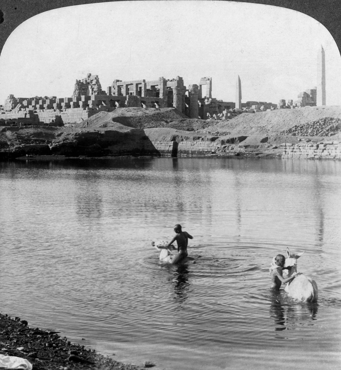 Ser över den heliga sjön till det stora templet i Karnak, Thebe, Egypten, 1905. av Underwood and Underwood