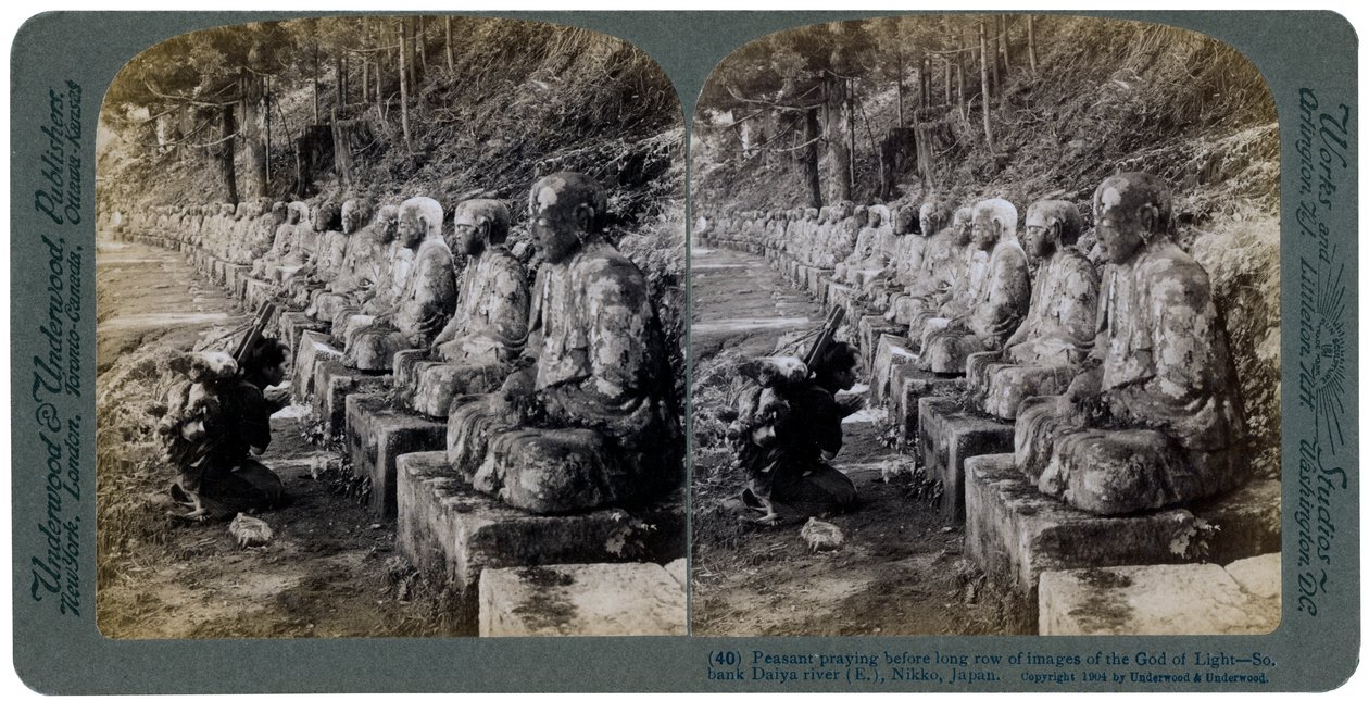 Bonde ber inför en rad statyer av ljusets gud, Daiya-floden, Nikko, Japan, 1904. av Underwood and Underwood