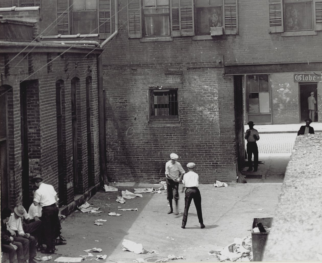 Group of men and boys in an unidentified courtyard-alley av Unknown