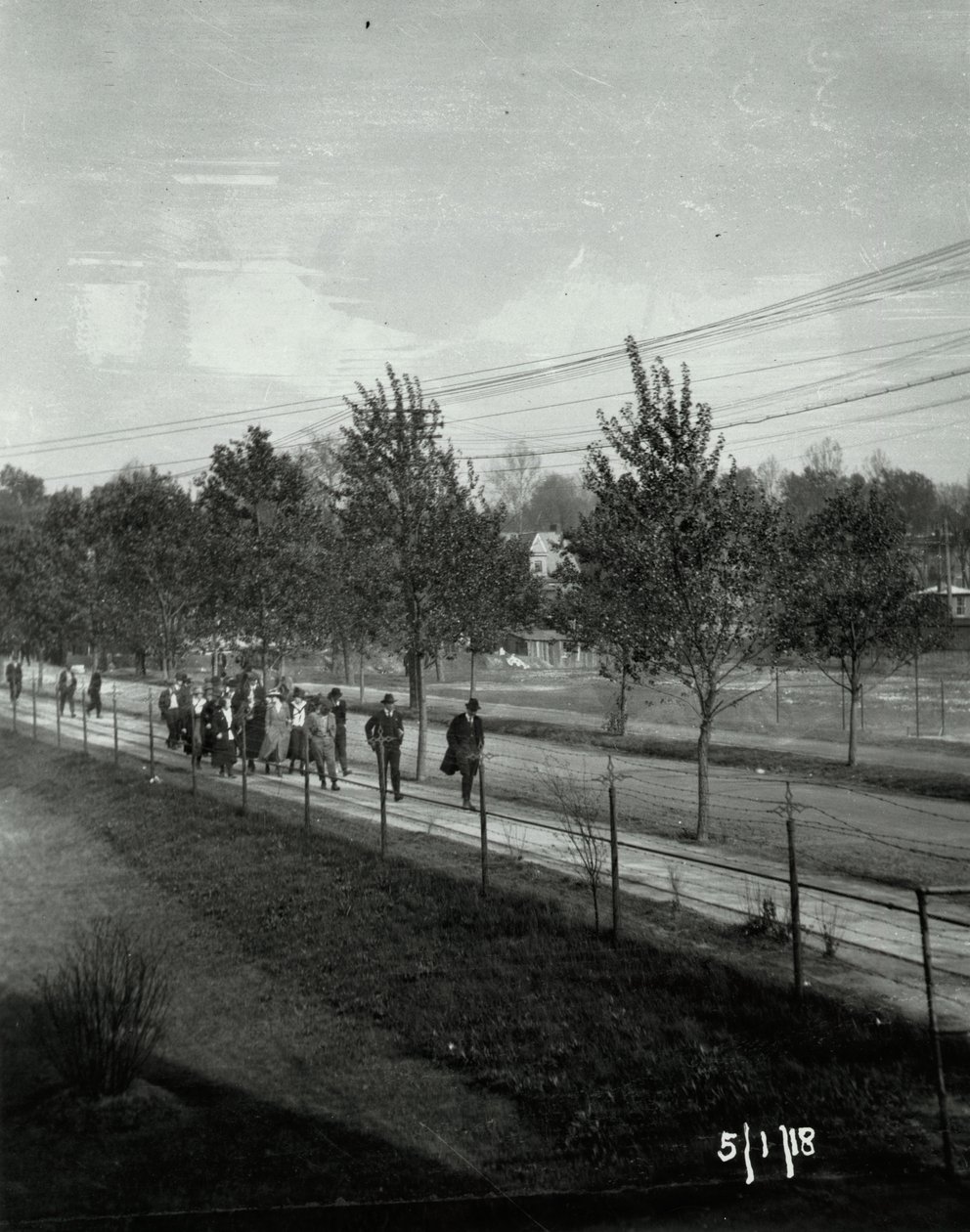 Wagner Electric Company strike; group of men and women walking on sidewalk av Unknown
