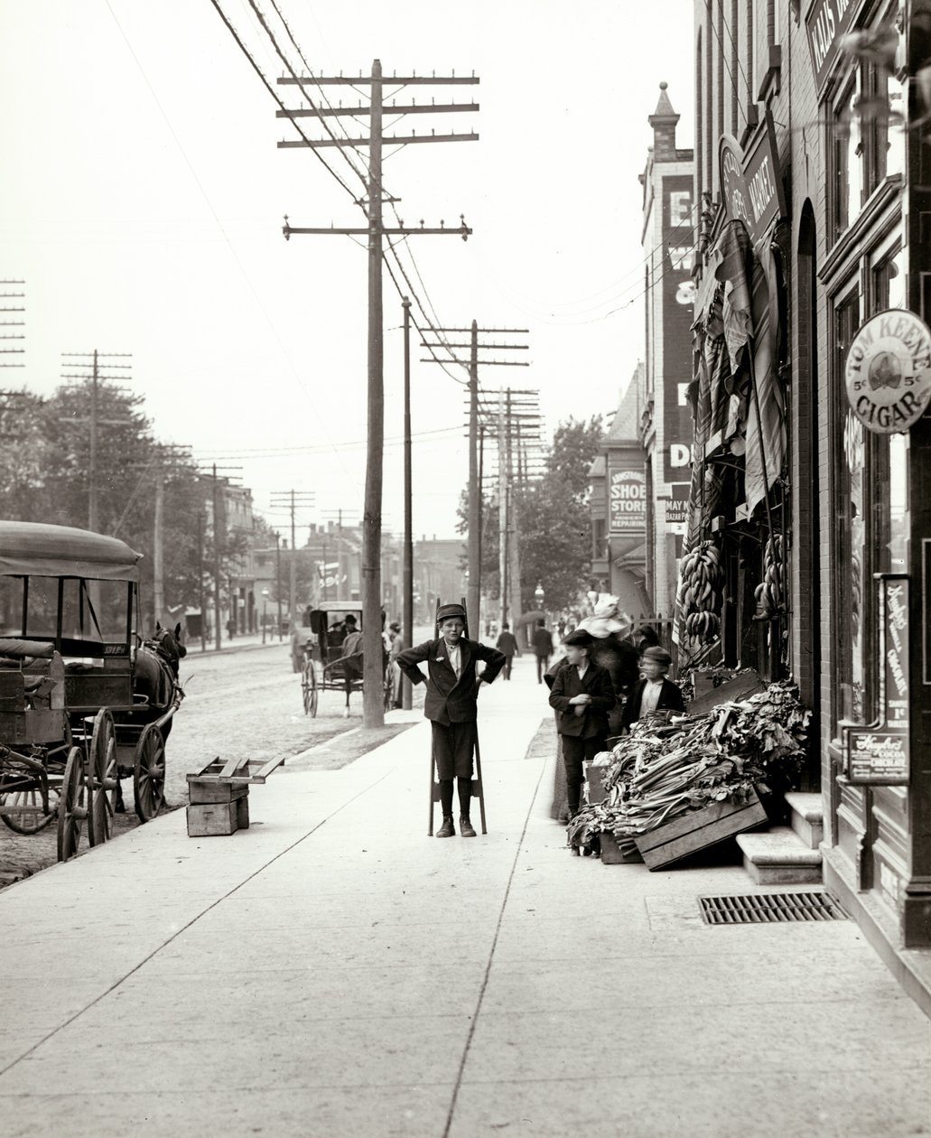 A boy with stilts standing in front of the F.J. Voepel Market at 4874 Easton Avenue, at the southeast corner of Easton and Euclid. Easton was later known as Dr. Martin Luther King Drive av Unknown