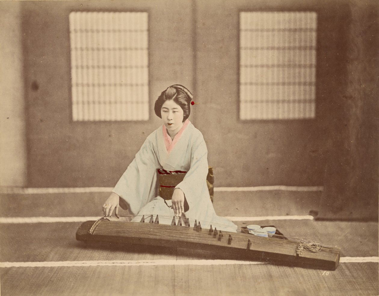 [Japansk kvinna som spelar koto] av Unknown artist