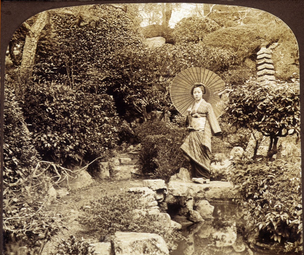 Japanskt kimonoparaply i en trädgård - fotografi, sent 1800-tal av Unknown photographer